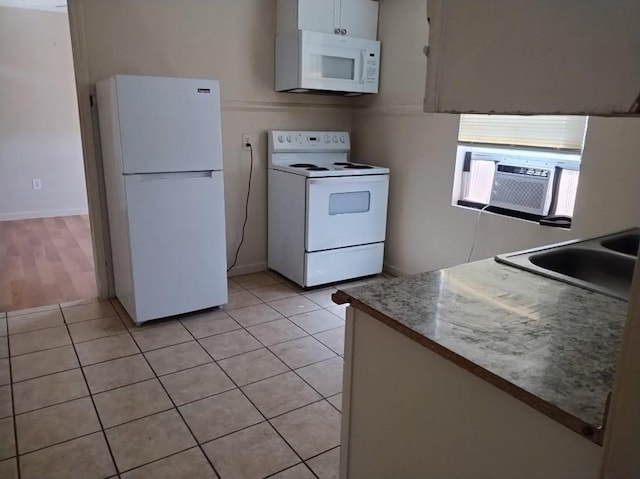 kitchen with white cabinets, white appliances, sink, and light tile flooring