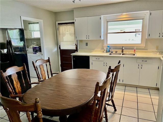 kitchen with white cabinets, light tile patterned flooring, sink, and washer / clothes dryer