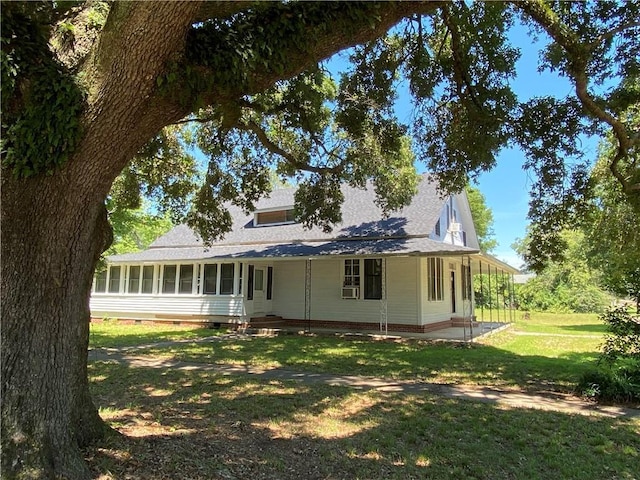 back of house with a lawn and a sunroom