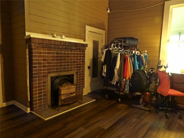 interior space with dark hardwood / wood-style flooring and wood walls