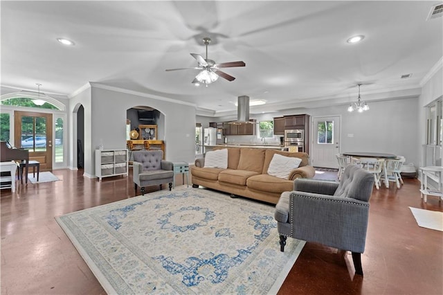 living room featuring crown molding and ceiling fan with notable chandelier