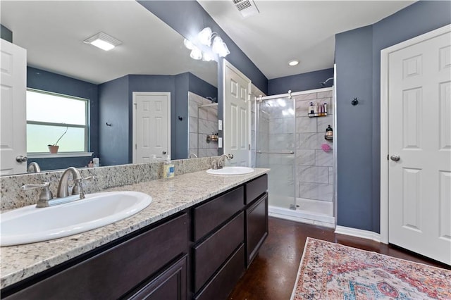 bathroom with walk in shower, oversized vanity, and double sink