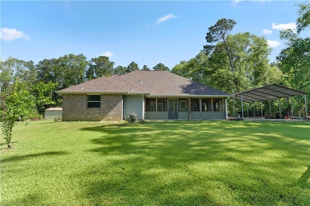 rear view of house featuring a yard and a carport