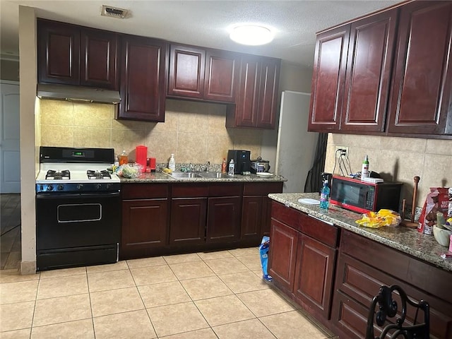 kitchen featuring light tile floors, sink, tasteful backsplash, gas range gas stove, and stone counters