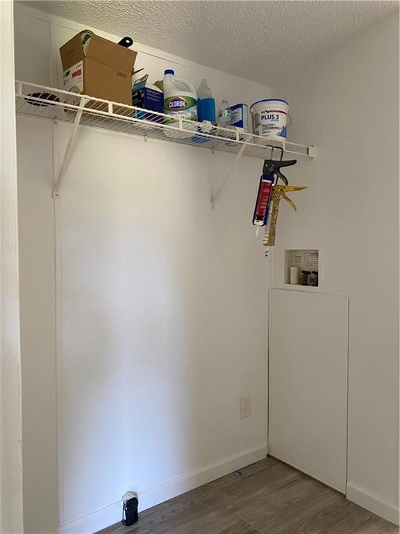 washroom featuring hardwood / wood-style flooring, washer hookup, and a textured ceiling