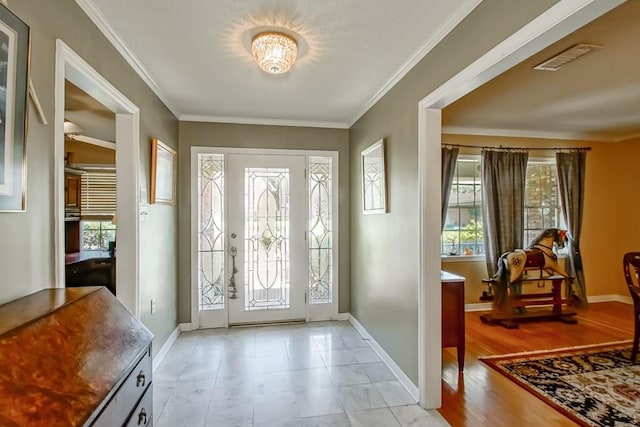 entryway featuring ornamental molding, a healthy amount of sunlight, and light tile floors