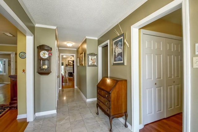 hall with crown molding, tile flooring, and a textured ceiling