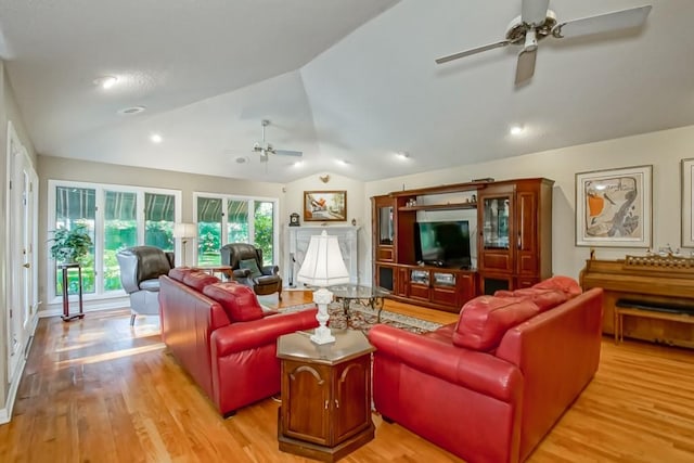 living room featuring lofted ceiling, ceiling fan, and light hardwood / wood-style flooring