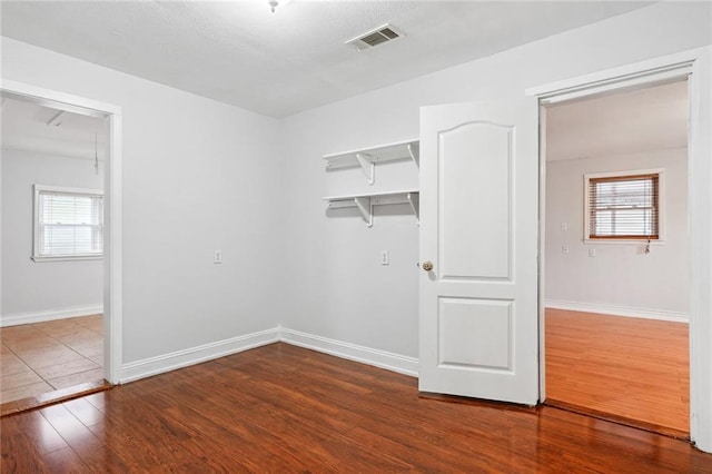 unfurnished room with a wealth of natural light and dark hardwood / wood-style flooring