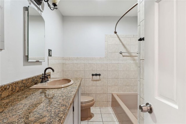 full bathroom featuring tiled shower / bath combo, tile walls, vanity, tile flooring, and toilet