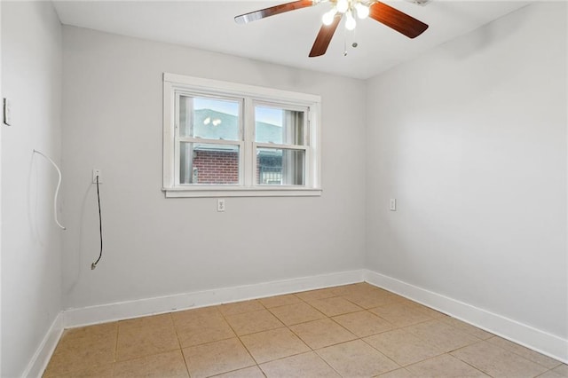 spare room with ceiling fan and light tile floors