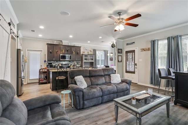 living room with a wealth of natural light, light hardwood / wood-style floors, and ornamental molding