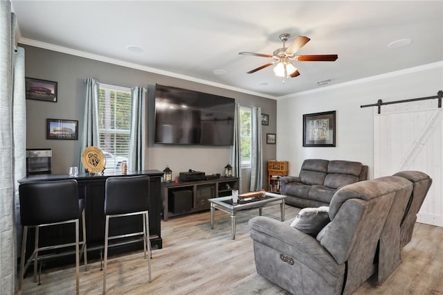 living room with hardwood / wood-style flooring, crown molding, a barn door, and ceiling fan