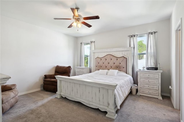 bedroom featuring light colored carpet, ceiling fan, and multiple windows