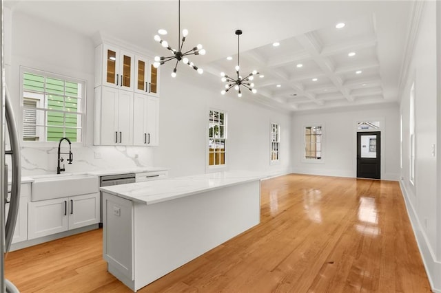 kitchen with a center island, sink, hanging light fixtures, and white cabinets