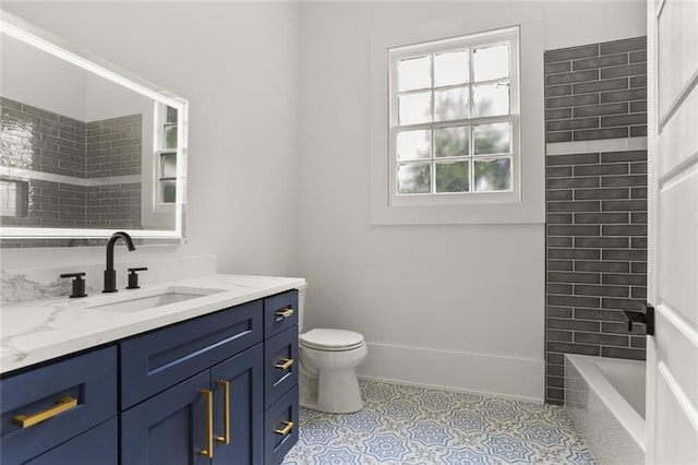 full bathroom featuring tile patterned flooring, vanity, tiled shower / bath, and toilet