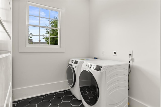 laundry area with separate washer and dryer and dark tile patterned flooring