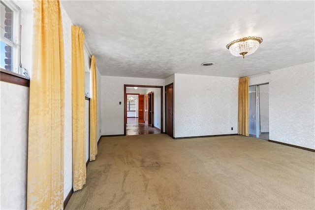 unfurnished room featuring carpet flooring and a textured ceiling