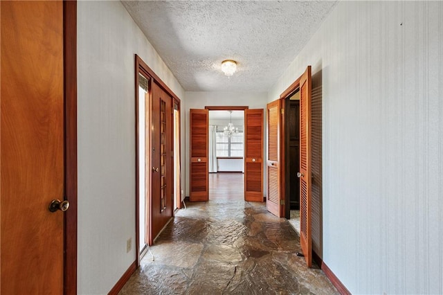 corridor with tile flooring and a textured ceiling