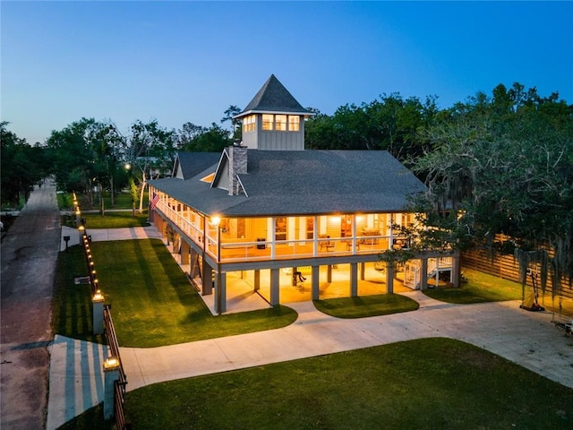 rear view of house featuring a yard and fence