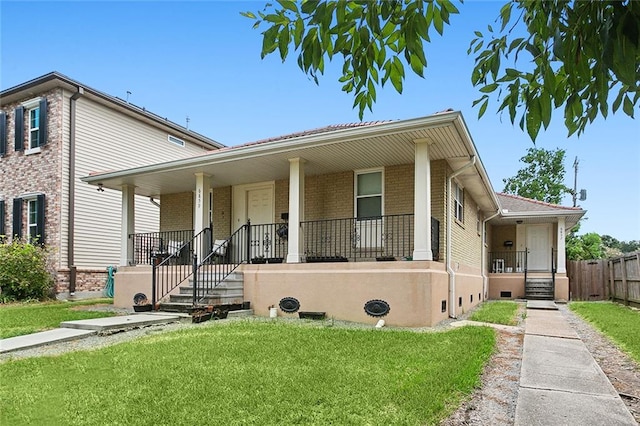 view of front of house featuring covered porch and a front yard