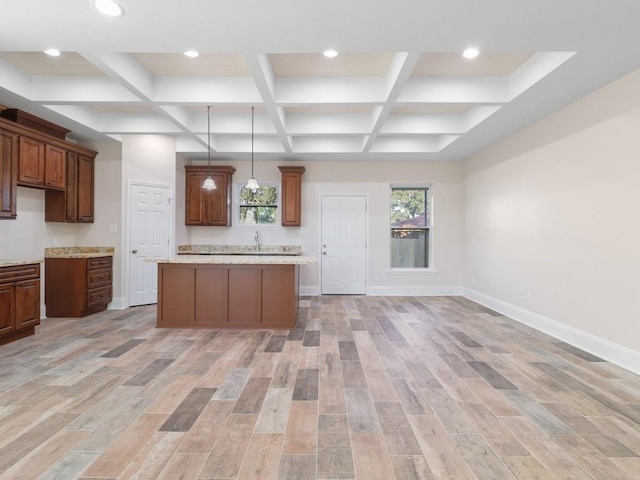 kitchen featuring a center island, coffered ceiling, light hardwood / wood-style floors, hanging light fixtures, and beam ceiling