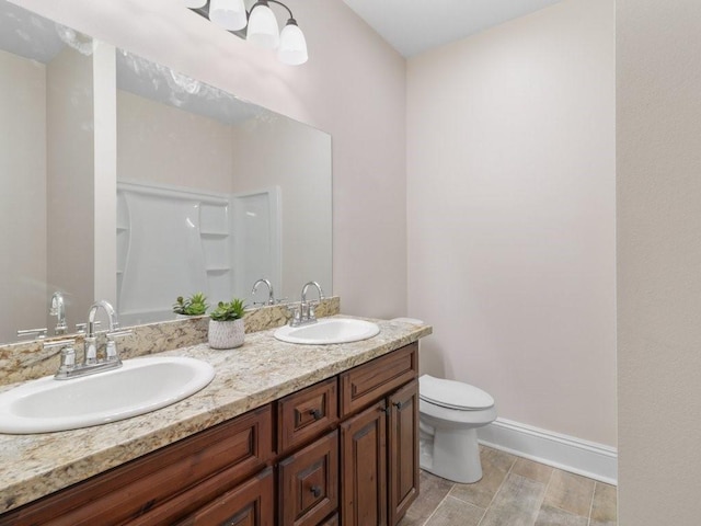 bathroom featuring tile flooring, toilet, and dual vanity