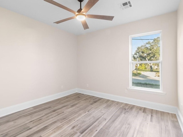 spare room featuring light hardwood / wood-style floors, a healthy amount of sunlight, and ceiling fan