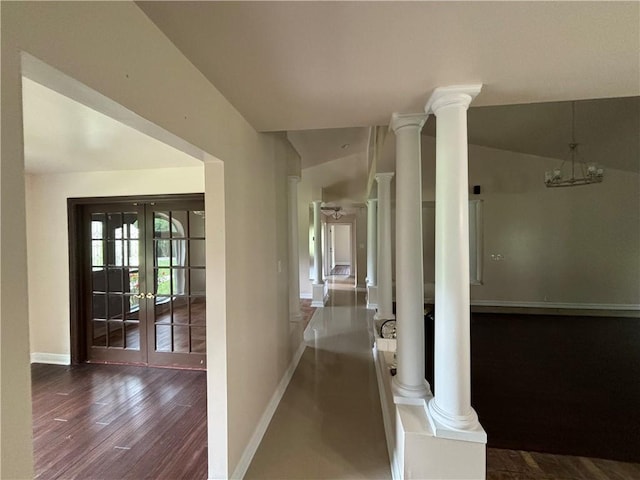 hall with french doors, dark hardwood / wood-style floors, decorative columns, and lofted ceiling