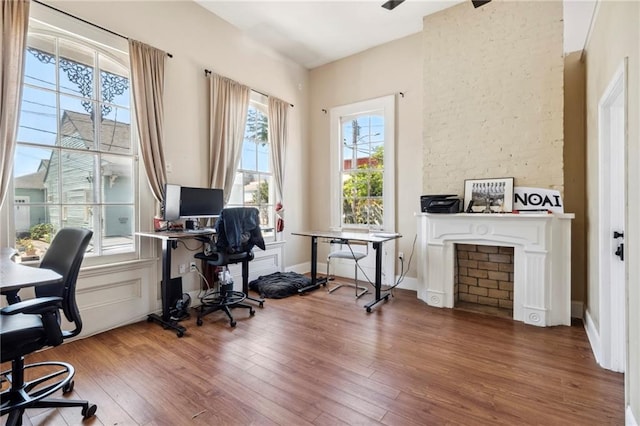 home office featuring wood-type flooring and a fireplace