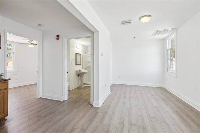 interior space with ensuite bath and light wood-type flooring