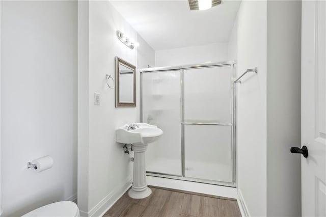 bathroom with walk in shower, hardwood / wood-style flooring, and toilet