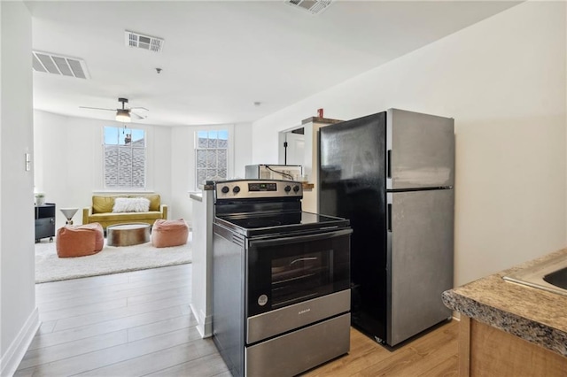 kitchen featuring light hardwood / wood-style floors, ceiling fan, and stainless steel appliances