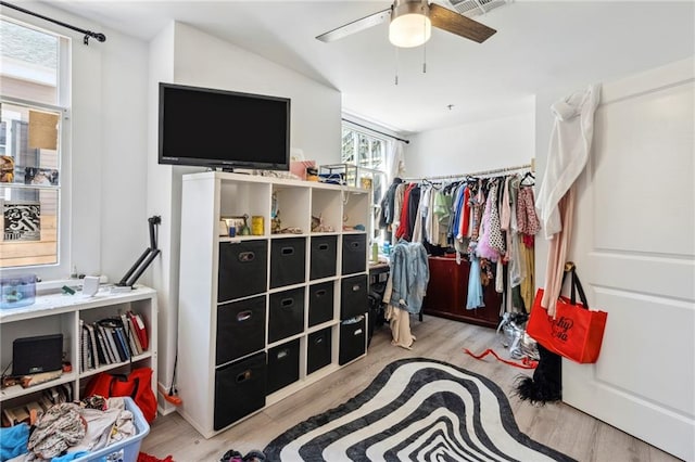 walk in closet with light hardwood / wood-style flooring and ceiling fan