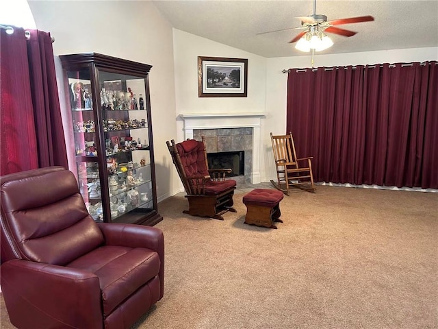 sitting room featuring a fireplace, ceiling fan, carpet, and lofted ceiling