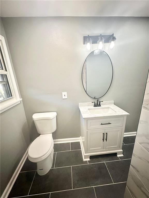 bathroom featuring vanity with extensive cabinet space, toilet, and tile flooring