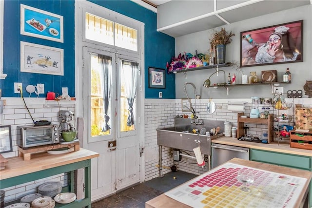 kitchen featuring a wood stove, stainless steel dishwasher, and sink