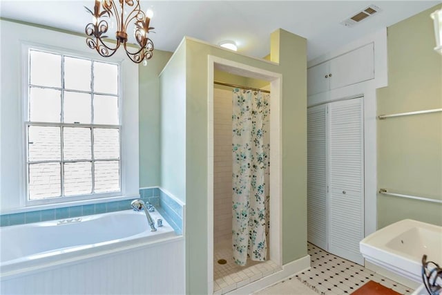 bathroom featuring a notable chandelier, tile floors, and separate shower and tub