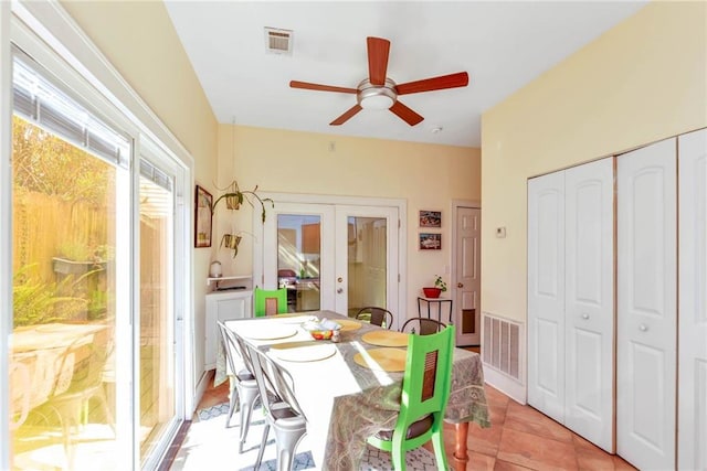 tiled dining room with ceiling fan and french doors