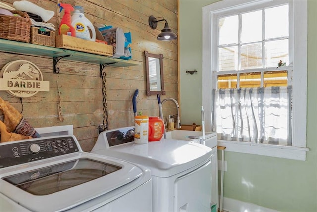 clothes washing area featuring independent washer and dryer, wooden walls, and hookup for a washing machine