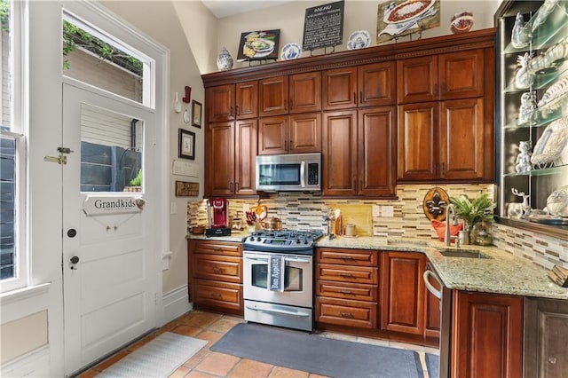 kitchen with decorative backsplash, light tile patterned floors, stainless steel appliances, and a wealth of natural light