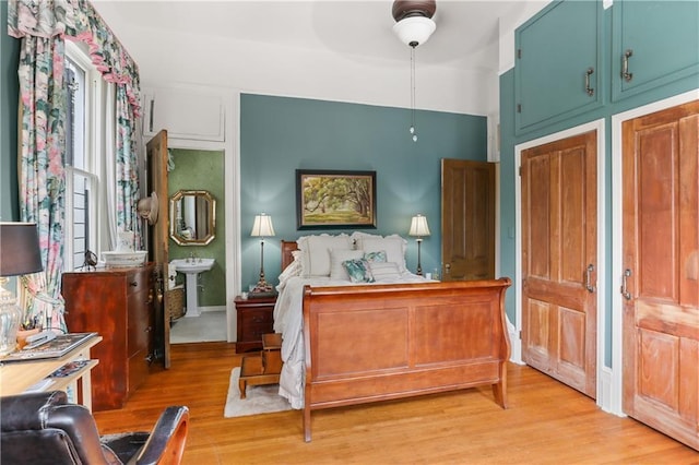 bedroom with light hardwood / wood-style floors, ceiling fan, and sink