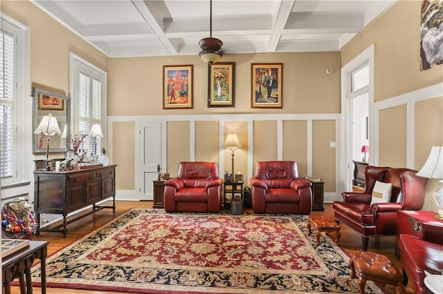 living area featuring beamed ceiling, ceiling fan, hardwood / wood-style flooring, and coffered ceiling