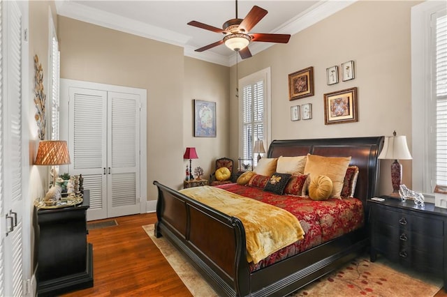 bedroom featuring ceiling fan, a closet, dark wood-type flooring, and ornamental molding