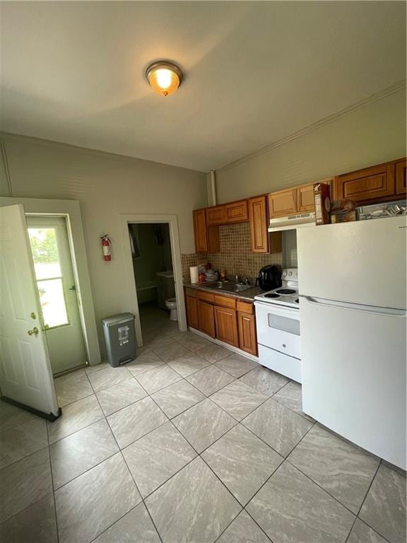 kitchen with white appliances, tasteful backsplash, sink, and light tile floors