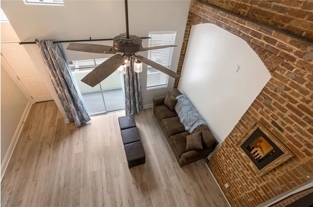 living room with brick wall, ceiling fan, and hardwood / wood-style flooring