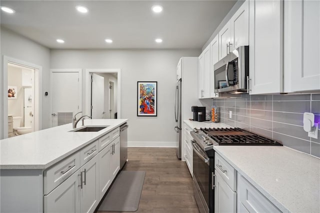 kitchen featuring dark hardwood / wood-style flooring, white cabinetry, stainless steel appliances, sink, and tasteful backsplash