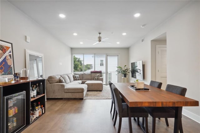 dining room with wood-type flooring, ceiling fan, and beverage cooler