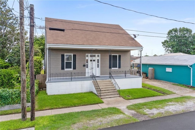 bungalow-style house featuring covered porch and a front lawn