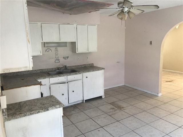 kitchen with sink, ceiling fan, light tile floors, and white cabinetry